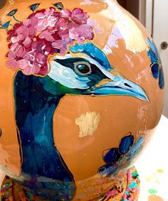 a vase with a bird painted on it's face and flowers in its beak