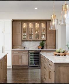 a kitchen filled with lots of wooden cabinets and counter top space next to a wine cooler