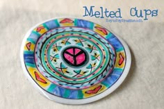 a colorful plate with a pink heart on it sitting on top of a white tablecloth