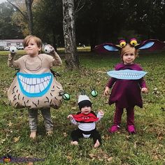 three children dressed up as monsters in the grass