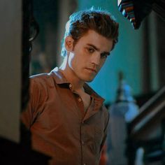 a young man standing in front of a stair case