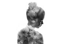 a black and white photo of a woman's profile with flowers in her hair