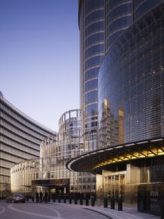 an empty street in front of some very tall buildings with glass and steel windows on the sides