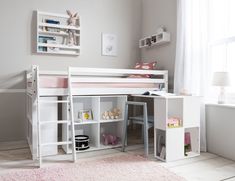 a child's bedroom with a desk and bunk bed in the corner, pink rug on the floor