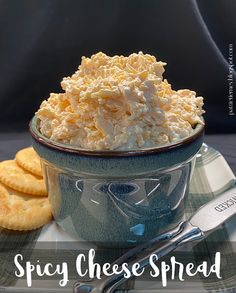 a blue bowl filled with shredded cheese next to crackers