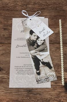 an image of a wedding card on a table with two candles and some paper straws