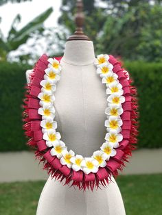 a white and yellow flower lei on a mannequin