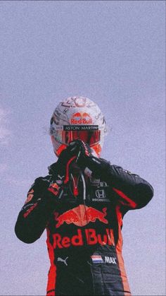 a man wearing a red bull racing suit and helmet