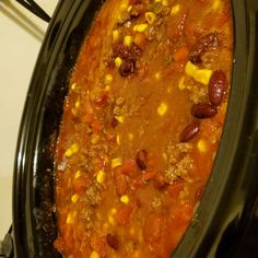 a crock pot filled with chili and corn