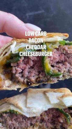 a hand holding up a sandwich with meat and cheese on it, in front of the words low carb bacon cheddar cheeseburger