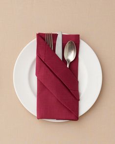 a white plate topped with a red napkin and silverware