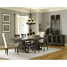 a dinning room table with chairs and a rug on the floor in front of it