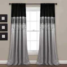 black and grey curtains with silver sequins are hanging in front of a window