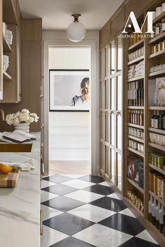 a kitchen with black and white checkered flooring next to shelves filled with food