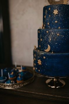 there is a blue cake with stars and moon decorations on it