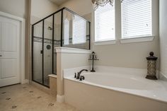 a bathroom with a tub, shower and window