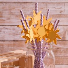 a mason jar filled with paper flowers and straws