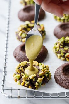 a spoon drizzling sauce onto some cookies