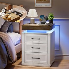 a night stand with three drawers and a phone on it, next to a bed