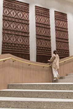 a man is standing on the stairs in front of some decorative wall panels