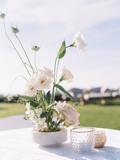 white flowers are in a vase on a table