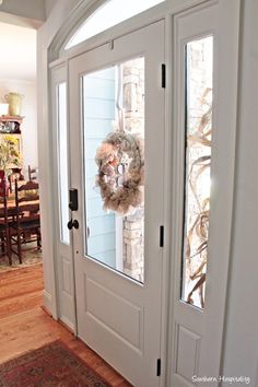 the front door is decorated with wreaths on it's glass windows and doors