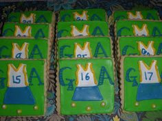 four decorated cookies in the shape of hats with numbers and crowns are on a table