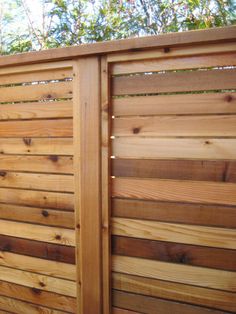 a wooden fence that is next to some trees