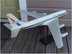 a model airplane sitting on top of a wooden floor next to a door and steps