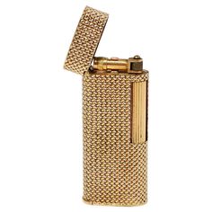 Discover a remarkable piece of history with the Van Cleef & Arpels 1960s Dunhill 18k Solid Gold Refillable Lighter. This exquisite lighter showcases a stunning woven design that combines both yellow and white gold, exemplifying the luxury craftsmanship that the brand is renowned for. Crafted from 18k solid gold, this lighter is not just a functional accessory but also a standout collectible that reflects a bygone era of sophistication. The bottom of the lighter features the custom engraved initials of the original owner, adding a unique touch to this already special piece. Style this lighter with other fine items, such as a Cartier must-watch, a Bvlgari Serpenti bracelet, or a Hermès leather wallet to embody a cohesive luxurious aesthetic. Whether displayed as a collector's item or simply Bvlgari Serpenti Bracelet, Refillable Lighter, Luxurious Aesthetic, Adjustable Bag Strap, Bvlgari Serpenti, Van Cleef And Arpels, Engraved Initials, Leather Luggage Tags, Adjustable Bag