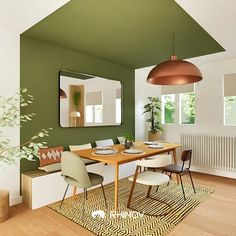 a dining room with green walls and wooden flooring is pictured in this image, there are chairs around the table