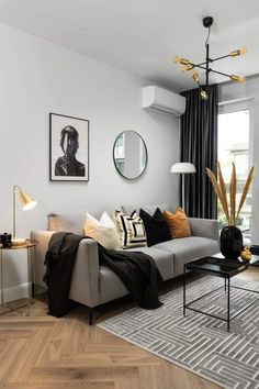 a living room filled with furniture next to a window covered in black and white curtains