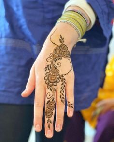 a woman's hand with henna tattoos on it