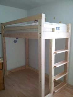 a wooden bunk bed sitting on top of a hard wood floor