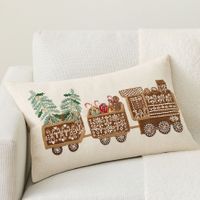 a white couch with a decorative pillow on it's back and an embroidered train