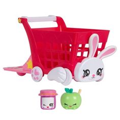 a toy shopping cart filled with toys like an apple, carrots and bunny ears