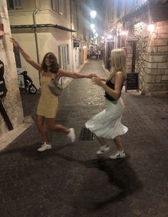 two women dancing in the street at night