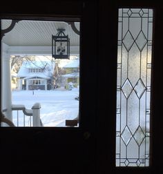 two glass doors open in front of a house with snow on the ground and trees