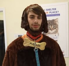 a man wearing a costume with a dog bone on his neck and a cat in the collar