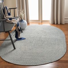 a living room with a chair and rug on the floor