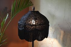 a lamp that is on top of a table next to a potted palm tree