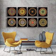 a living room with yellow chairs and artwork on the wall above it, along with a coffee table