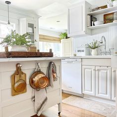 a kitchen with white cabinets and wooden utensils