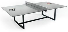 a ping pong table with two paddles resting on it's top and an object in the background