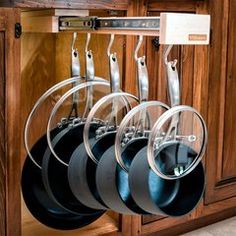 an image of pots and pans hanging on the rack in front of kitchen cabinets