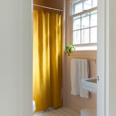 a bathroom with a yellow shower curtain next to a sink