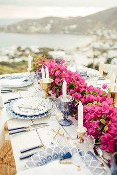 the table is set with purple flowers and candles