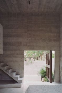 an open door leading to a bedroom with stairs in the wall and plants on the floor