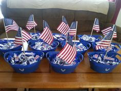 a table topped with blue buckets filled with american flags