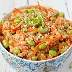 a bowl filled with rice, carrots and peas